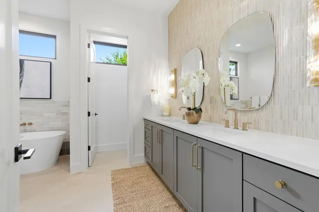 a spacious bathroom with a double vanity sink mirror and bathtub