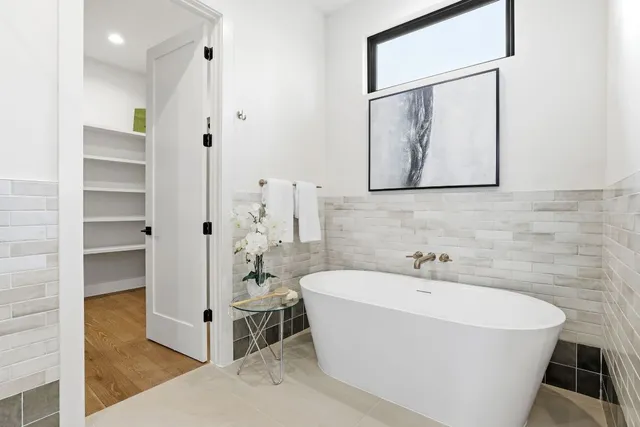 a white bath tub sitting next to a bathroom sink