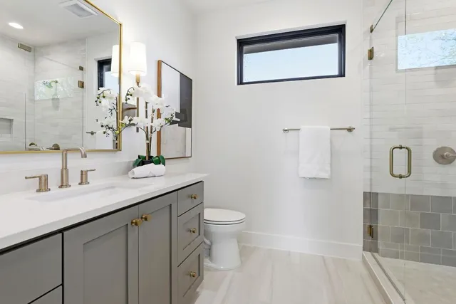 a bathroom with a granite countertop sink a toilet and a mirror