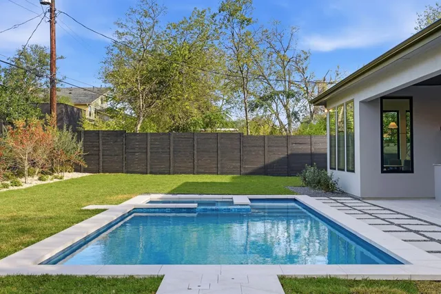 a view of backyard with swimming pool and outdoor seating