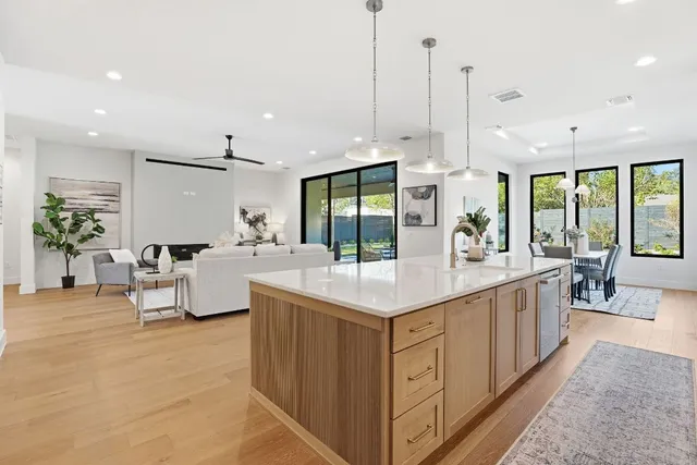 a large kitchen with kitchen island a large counter top a sink a stove and a large window