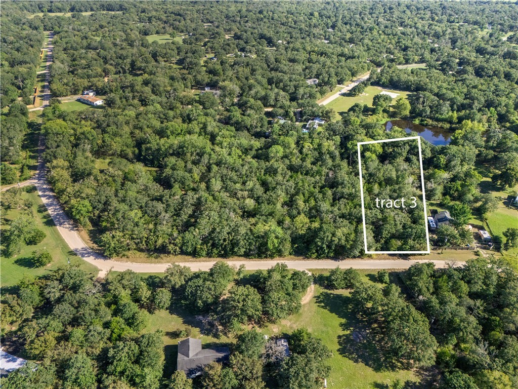 Aerial overview of property's location with property parcel outlined and a heavily wooded area