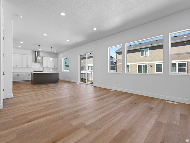 18 South Crimson Way, Unit 304 Mapleton, UT 84664 - Photo 6 of 17 Unfurnished living room with light wood-style floors, recessed lighting, and a textured ceiling