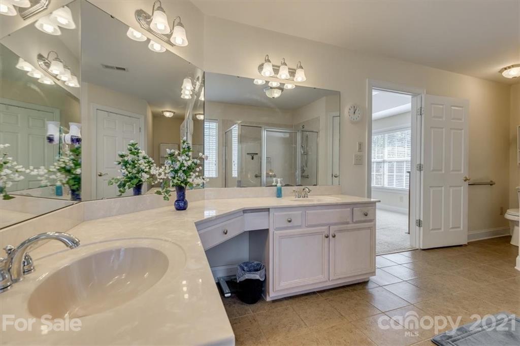 704 Beechnut Court Fort Mill, SC 29708 - Photo 32 of 46 a spacious bathroom with a granite countertop double vanity and a mirror