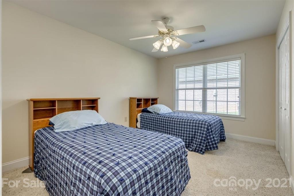 704 Beechnut Court Fort Mill, SC 29708 - Photo 33 of 46 a bedroom with two beds and a chandelier