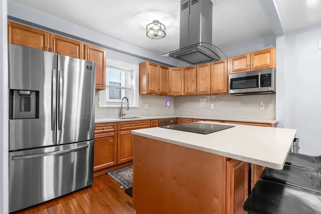 a kitchen with stainless steel appliances granite countertop a refrigerator a stove a sink and a microwave