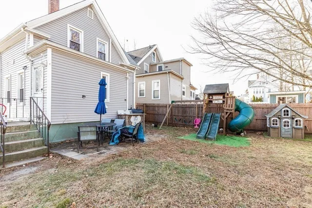 a view of a house with a patio and a yard