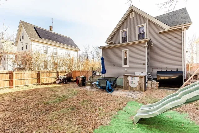 a view of a house with a yard and sitting area