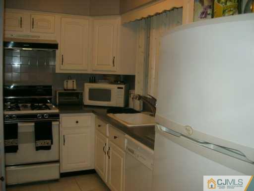 5 Chelsea Court Sayreville, NJ 08859 - Photo 6 of 8 a kitchen with granite countertop white cabinets and stainless steel appliances