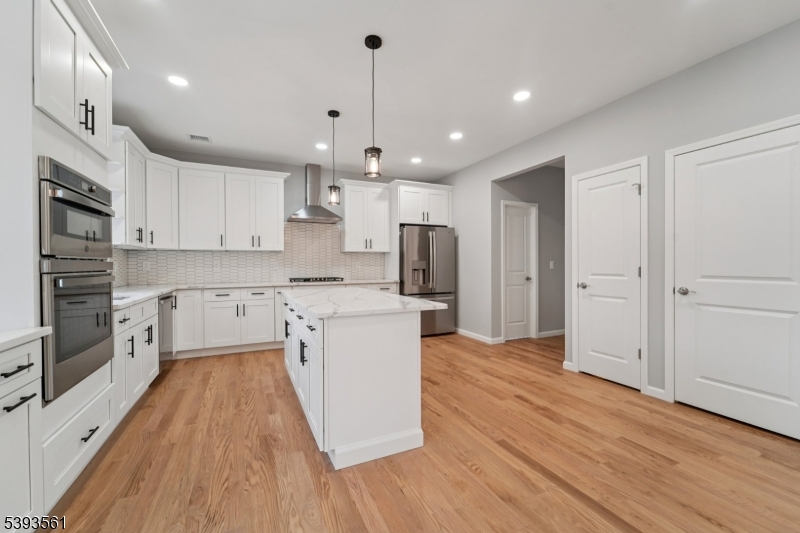 120 Addison Street Boonton, NJ 07005 - Photo 10 of 44 a kitchen with stainless steel appliances granite countertop a refrigerator a sink dishwasher a stove and white countertops with wooden floor