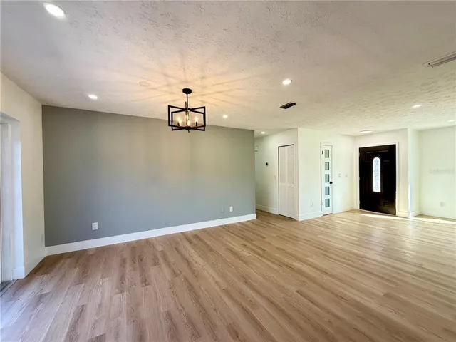 a view of empty room with wooden floor and ceiling fan