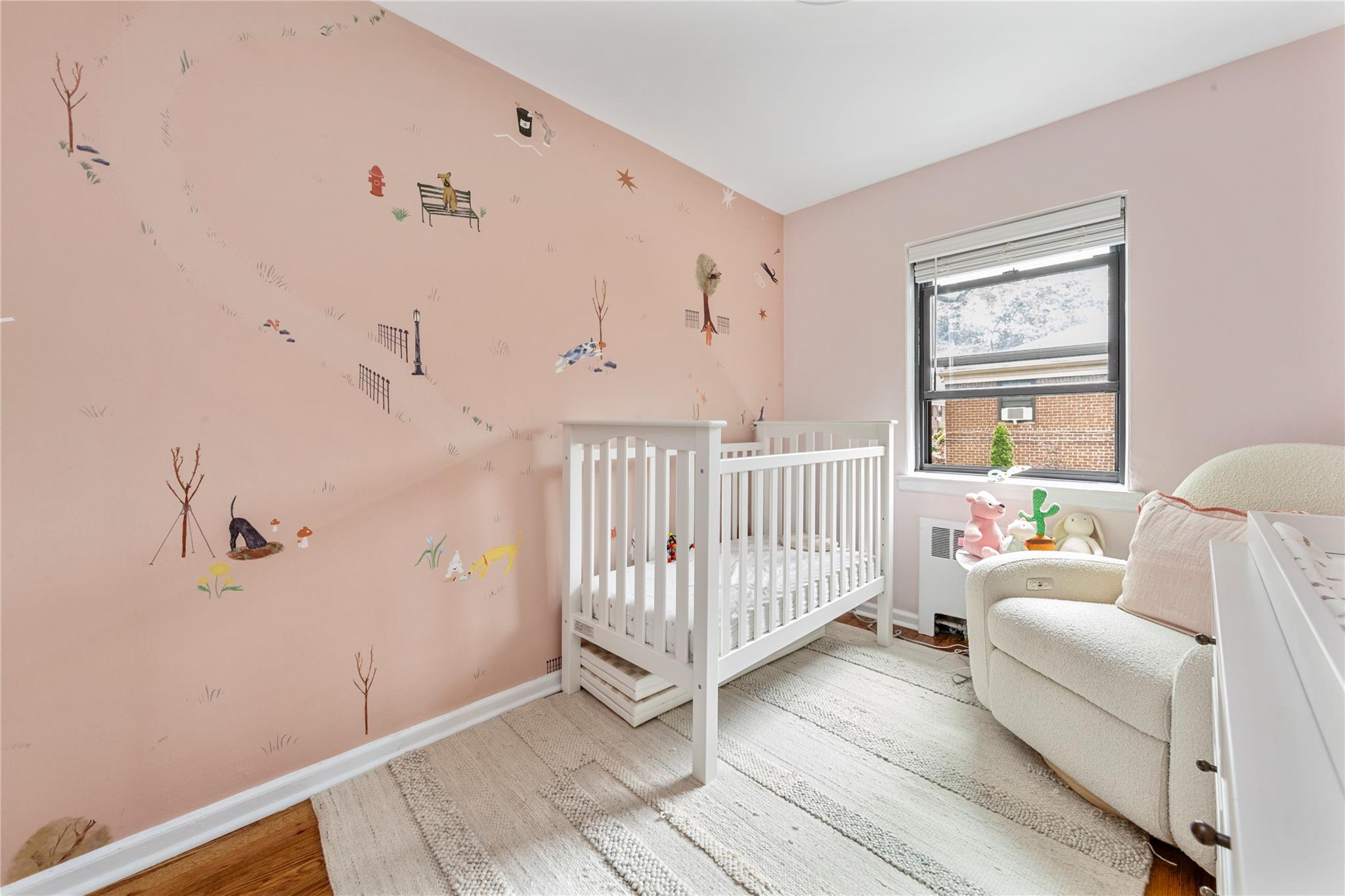 218-02 73rd Avenue, Unit UPPR Queens, NY 11364 - Photo 15 of 19 a room with a baby crib and a couch