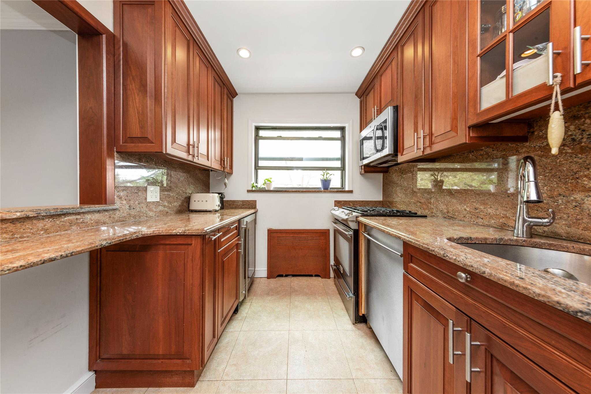 218-02 73rd Avenue, Unit UPPR Queens, NY 11364 - Photo 3 of 19 a kitchen with stainless steel appliances granite countertop a sink stove and cabinets