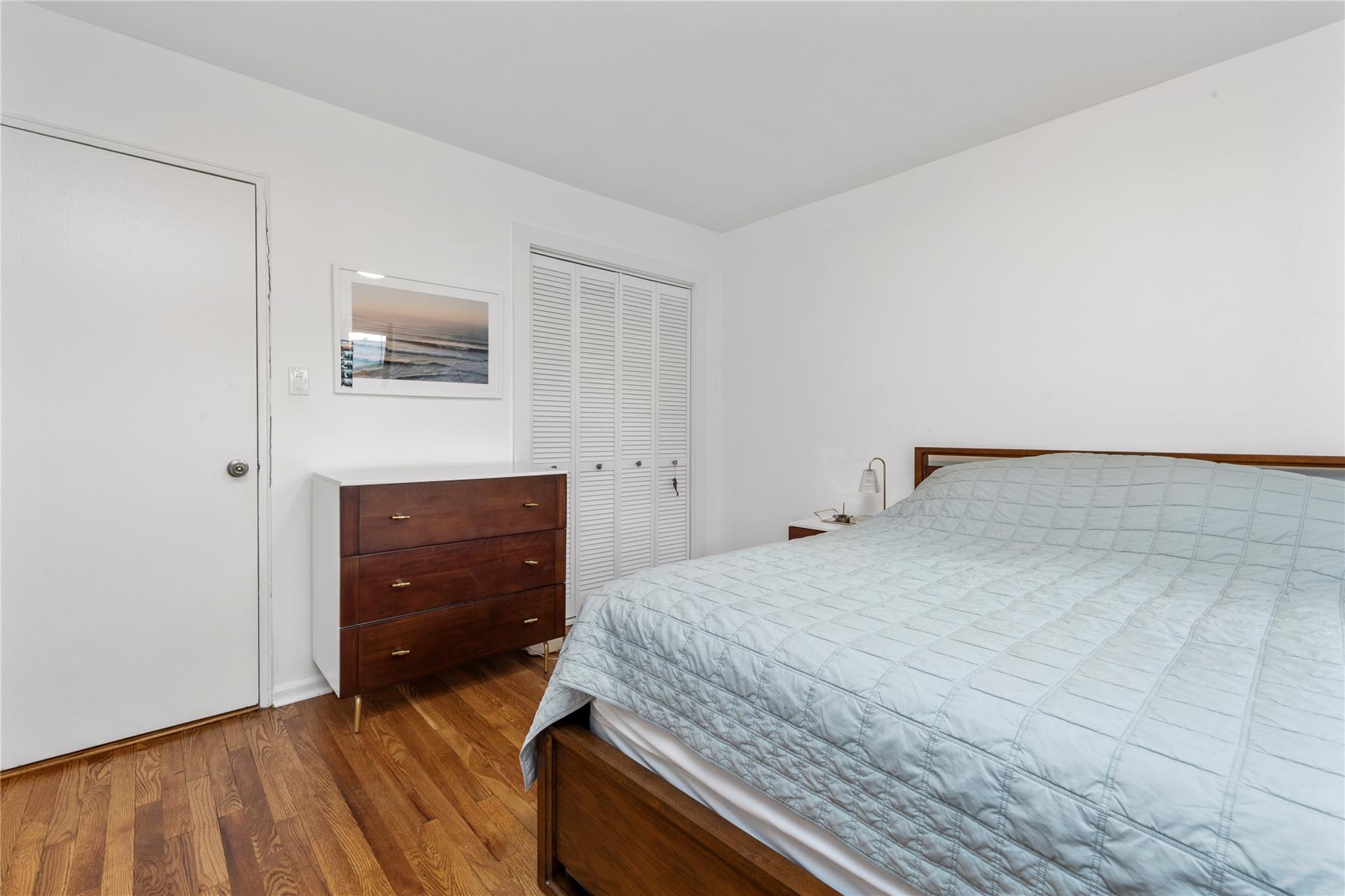 218-02 73rd Avenue, Unit UPPR Queens, NY 11364 - Photo 6 of 19 a bedroom with a bed and mirror