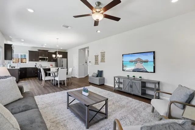 a living room with furniture and view of kitchen