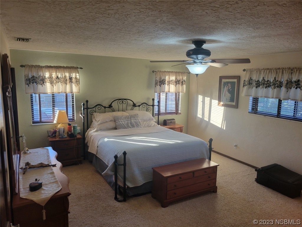 1012 South Riverside Drive Edgewater, FL 32132 - Photo 23 of 31 a bedroom with a bed mirror and window