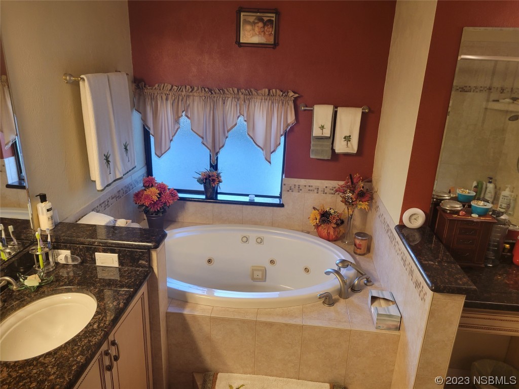 1012 South Riverside Drive Edgewater, FL 32132 - Photo 26 of 31 a bathroom with a tub sink and mirror