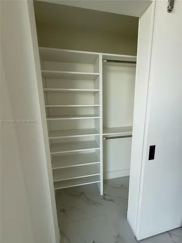 a view of walk in closet with empty racks