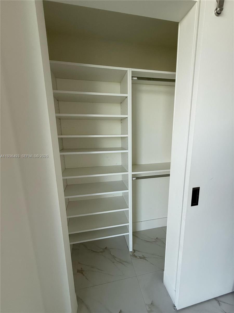 2000 Metropica Way, Unit 901 Sunrise, FL 33323 - Photo 12 of 19 a view of walk in closet with empty racks