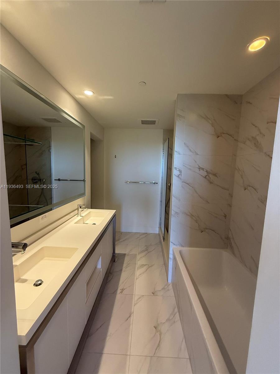 2000 Metropica Way, Unit 901 Sunrise, FL 33323 - Photo 15 of 19 a bathroom with a bathtub and a shower