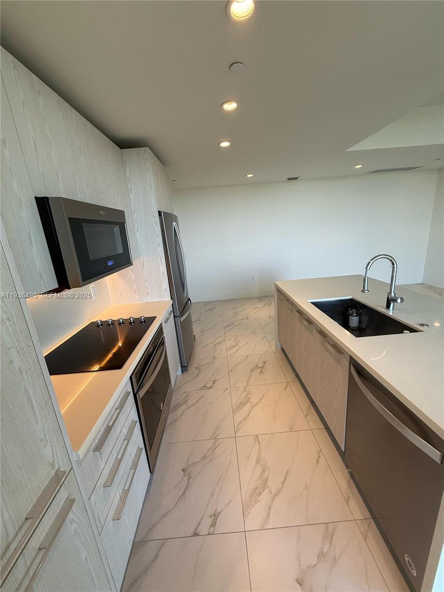 2000 Metropica Way, Unit 901 Sunrise, FL 33323 - Photo 6 of 19 a kitchen that has a sink and a stove