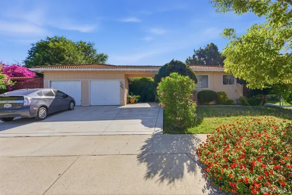 a front view of a house with a yard and a garden