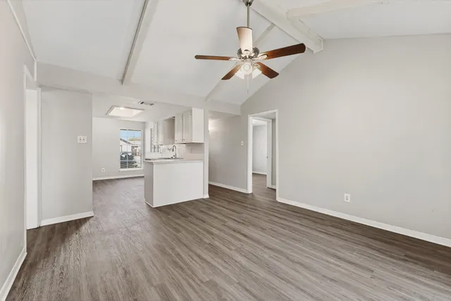 a view of a kitchen with wooden floor a sink and dishwasher