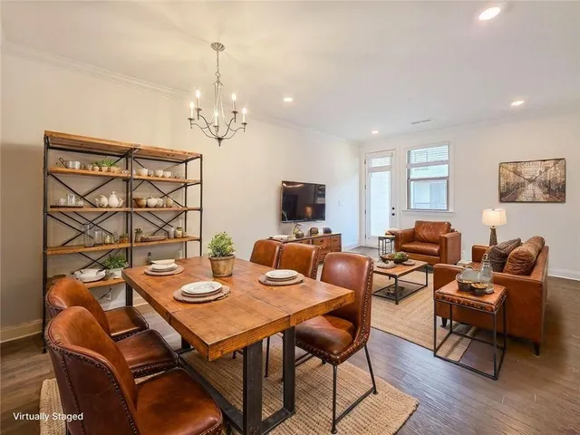 a living room with furniture a flat screen tv and kitchen view