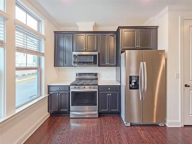 a kitchen with stainless steel appliances granite countertop a refrigerator microwave and stove