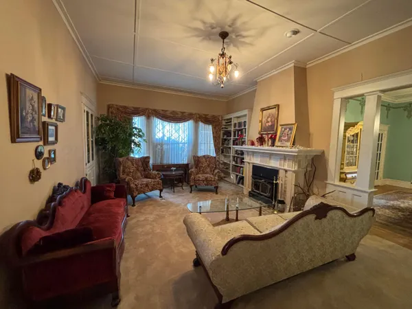 a living room with furniture a chandelier and a fireplace