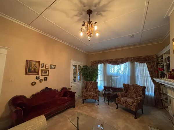 a living room with furniture a window and a chandelier