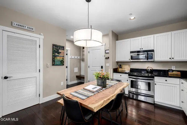 a kitchen with kitchen island a stove a table and chairs in it