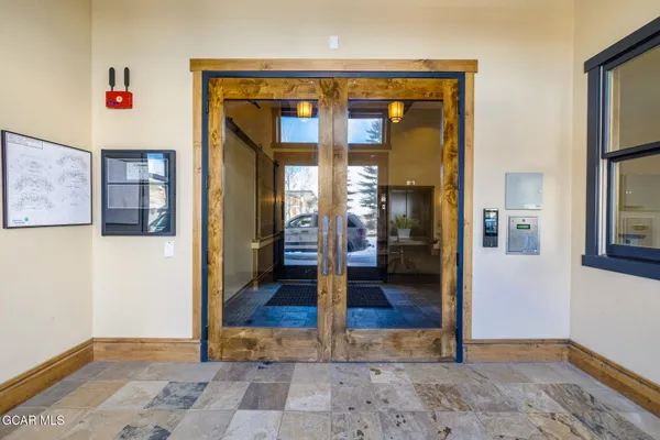 a view of a hallway with wooden floor and a living room