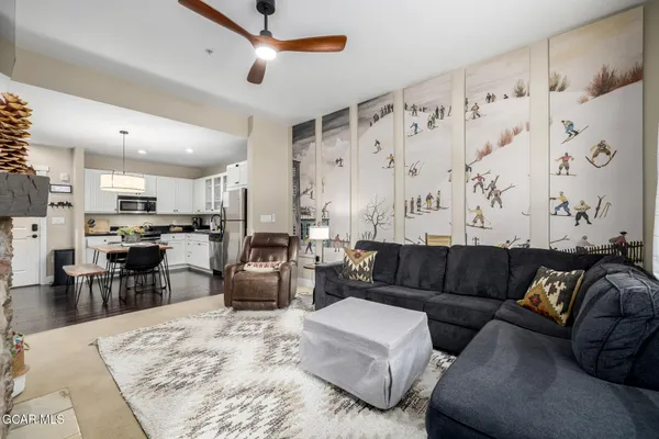 a living room with furniture kitchen view and a large window