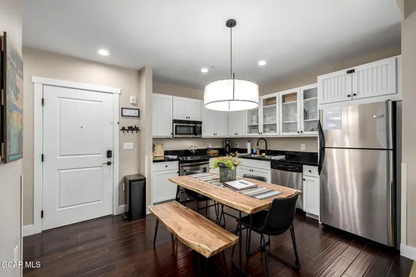 a kitchen with a refrigerator a stove a kitchen island a sink and a wooden floor