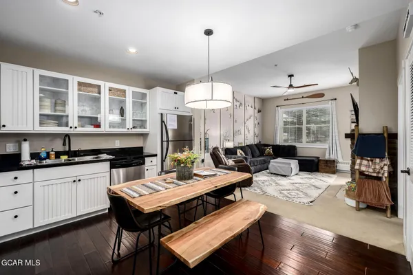a living room with furniture a fireplace and a open kitchen view
