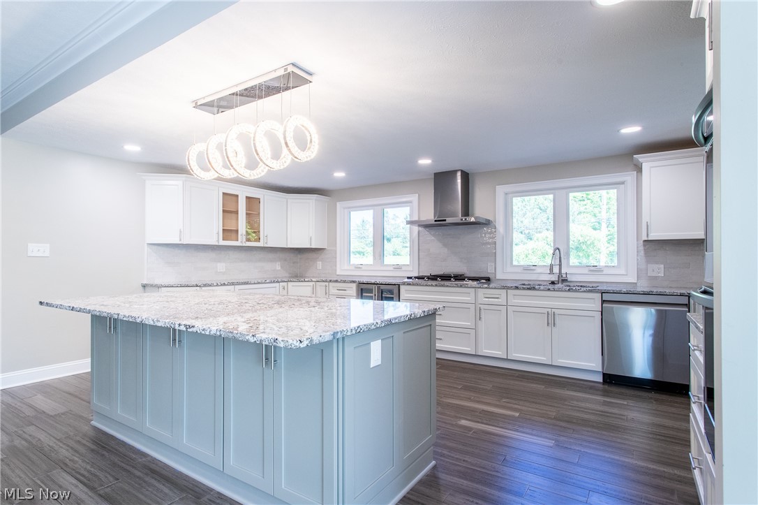2728 Lander Road Cleveland, OH 44124 - Photo 9 of 50 Kitchen with appliances with stainless steel finishes, wall chimney range hood, a center island, and dark hardwood / wood-style floors