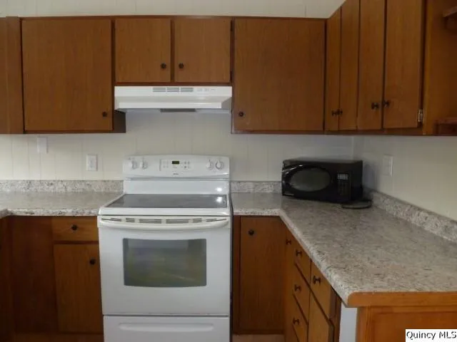 a kitchen with granite countertop cabinets stainless steel appliances and a counter space
