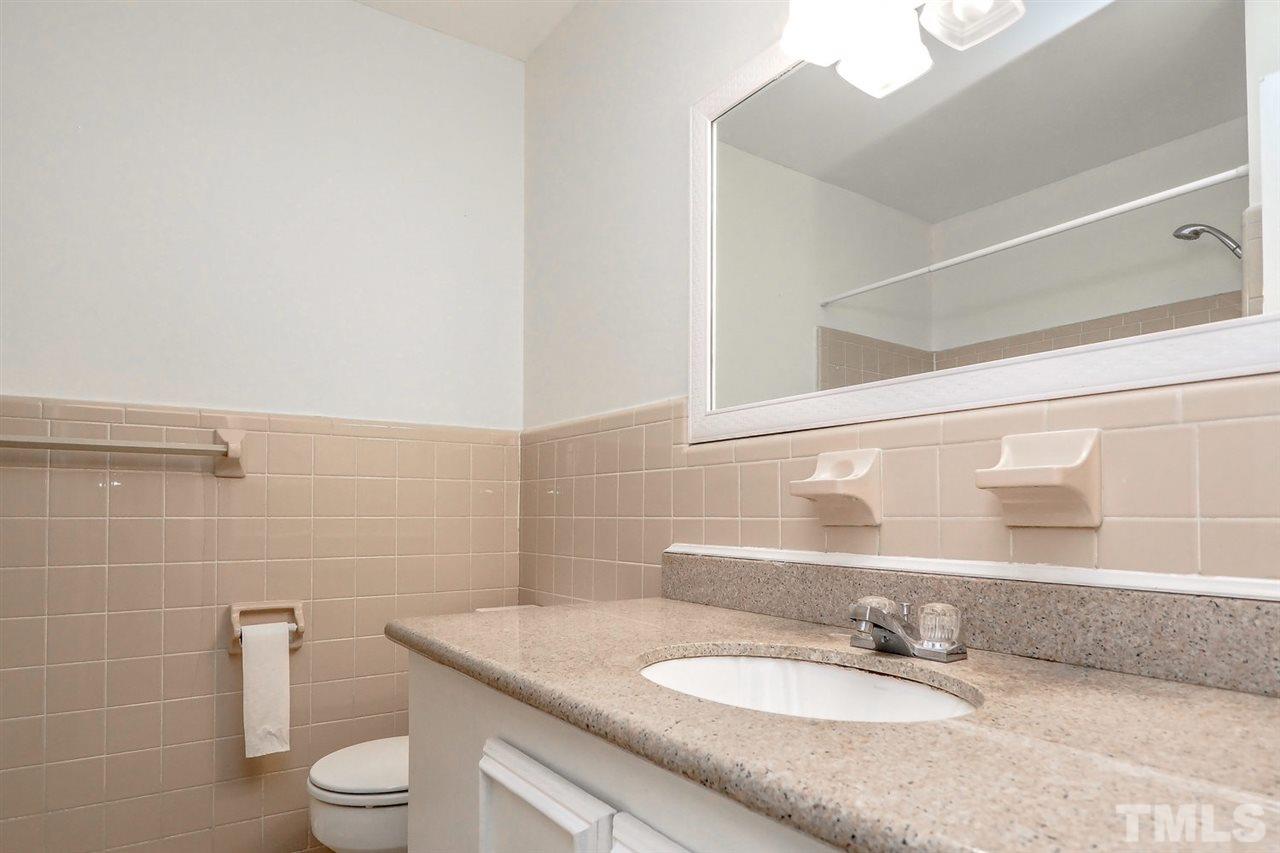 208 Winterlochen Road Raleigh, NC 27603 - Photo 8 of 25 a bathroom with a granite countertop sink a toilet and a mirror