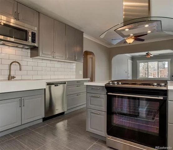 a kitchen with granite countertop a stove top oven microwave and cabinets