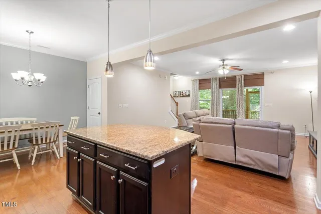 a kitchen with stainless steel appliances granite countertop a sink a stove and a wooden floors