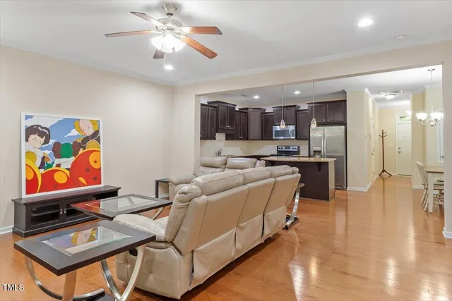 a living room with stainless steel appliances furniture and a kitchen view