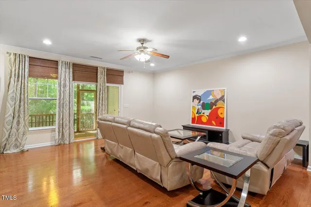 a living room with furniture and a flat screen tv with wooden floor