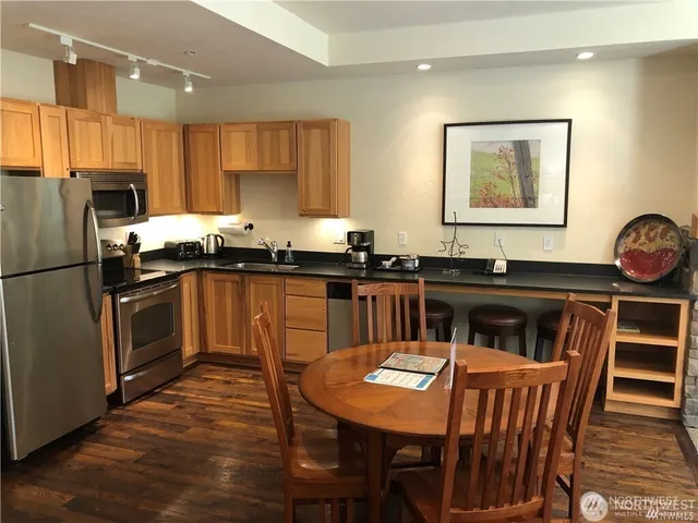 a kitchen with a table chairs stove and refrigerator