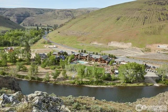 an aerial view of ocean and residential houses with outdoor space