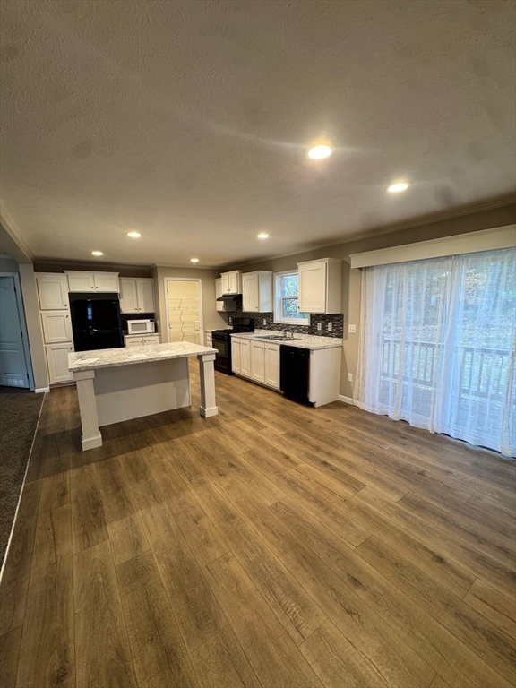 42 Kendell Lane Salisbury, MA 01952 - Photo 6 of 15 a large kitchen with stainless steel appliances kitchen island a large counter top and a stove top oven
