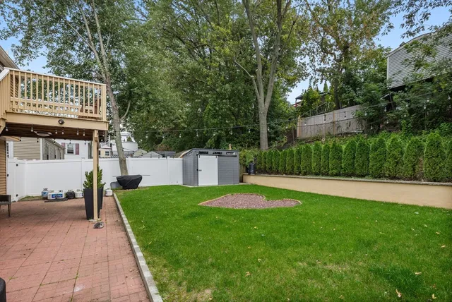 a view of a house with a patio and a yard