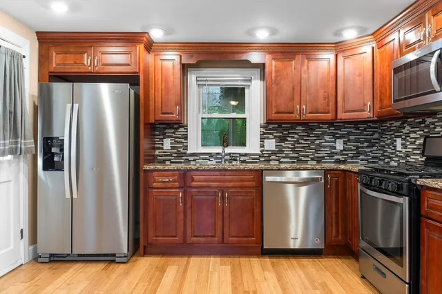 a kitchen with stainless steel appliances granite countertop a refrigerator and a sink