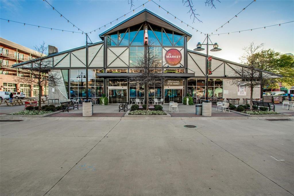 2220 Canton Street, Unit 101 Dallas, TX 75201 - Photo 19 of 20 Modern commercial building featuring extensive glass curtain walls, a prominent gable roofline, and a multi-story atrium