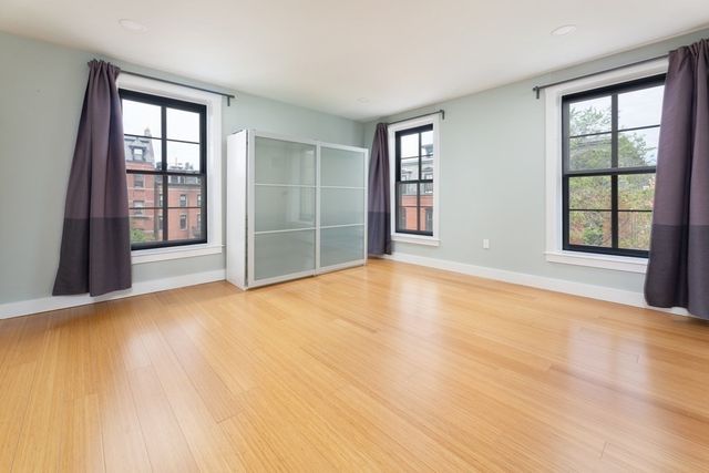 an empty room with windows and closet